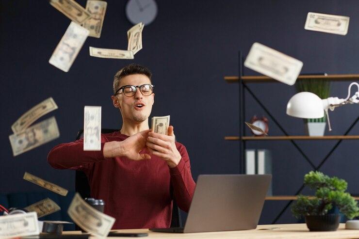 I'm rich. Portrait of a young freelancer or businessman in a home office. Throws cash. Successful deal. Earnings online. Win the money.